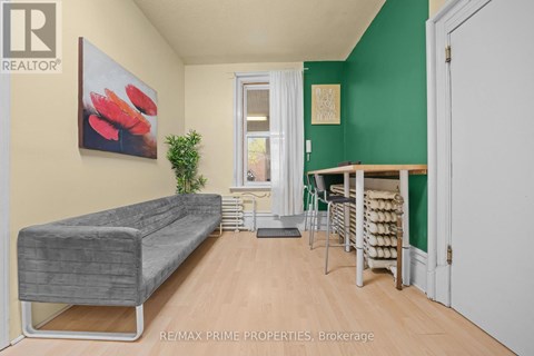 A living room with a grey couch and a green wall.