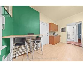 A dining area with a table and chairs in a room with green walls.