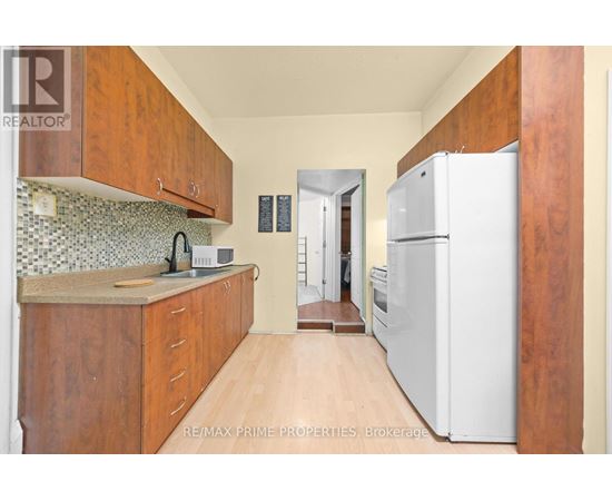 A kitchen with wooden cabinets and a white refrigerator.
