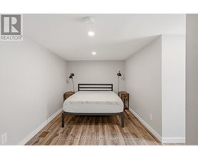 A bedroom with a bed, nightstands, and a ceiling light.