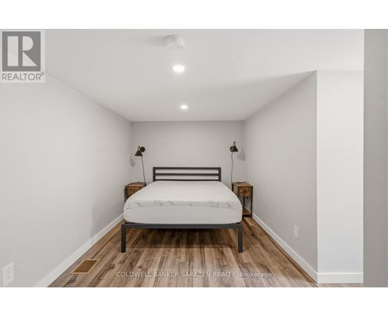 A bedroom with a bed, nightstands, and a ceiling light.