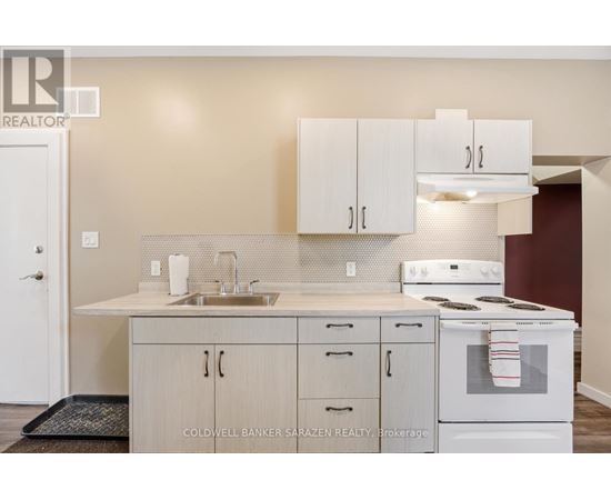 A kitchen with white cabinets and a white stove top oven.