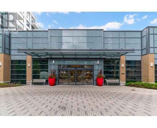 A modern building with a glass facade and a covered entrance.