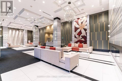 A modern living room with a white sofa set and a chandelier.