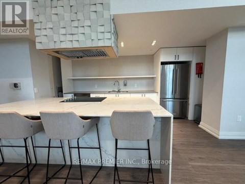 A kitchen with a white countertop and bar stools.