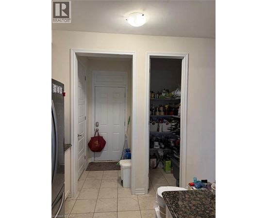 A kitchen with a refrigerator and a table.