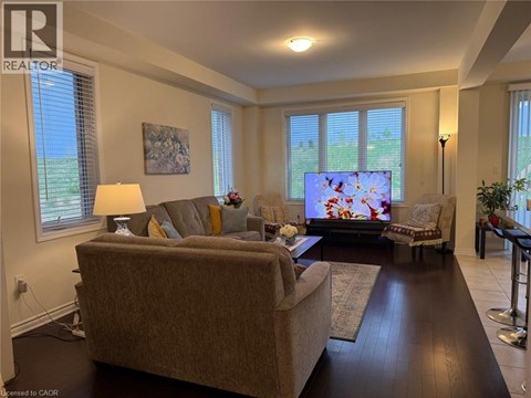 A living room with a couch, a chair, a television, and a painting on the wall.