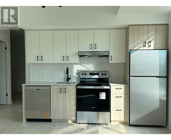 A modern kitchen with a refrigerator, oven, and sink.