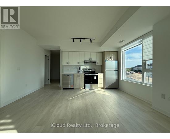 A kitchen with white cabinets and a stainless steel fridge is shown in this image.