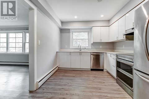 A kitchen with white cabinets and stainless steel appliances.