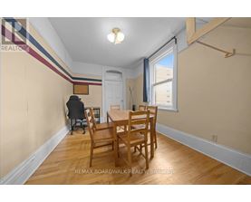 A dining room with a wooden table and chairs.