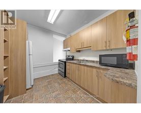 A kitchen with wooden cabinets and a black microwave.