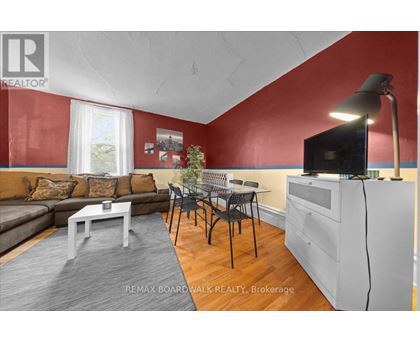 A living room with a grey sofa, a white coffee table, and a television on a cabinet.
