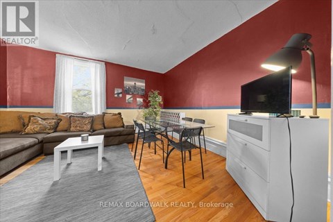 A living room with a grey sofa, a white coffee table, and a television on a cabinet.