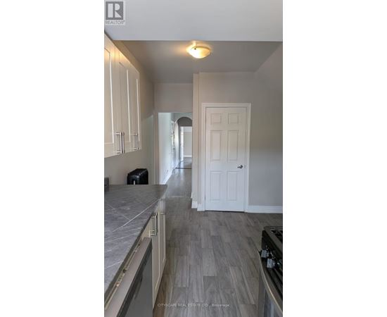 A kitchen with white cabinets and a white door.