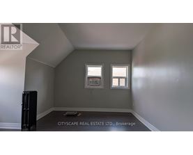 A room with a window and a radiator on the floor.