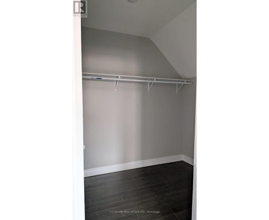 A room with a grey wall and a white door.