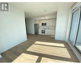 A sunny day with a room that has a fridge, microwave, and a small kitchenette.