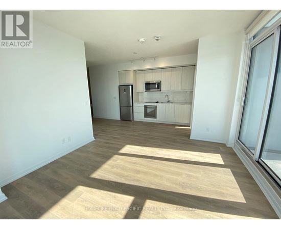 A sunny day with a room that has a fridge, microwave, and a small kitchenette.