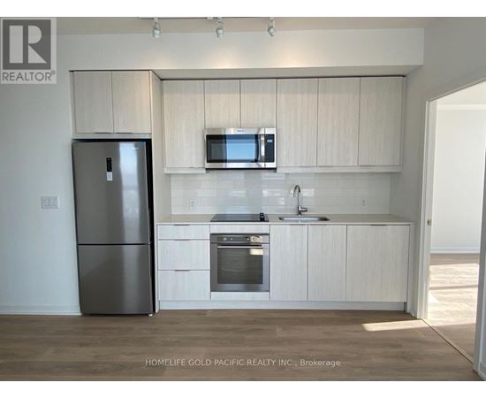 A kitchen with white cabinets and a stainless steel refrigerator.