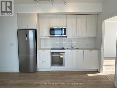 A kitchen with white cabinets and a stainless steel refrigerator.
