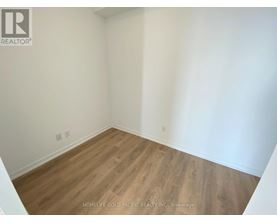 A room with wooden flooring and white walls.