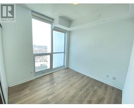 A room with a large window and wooden flooring.