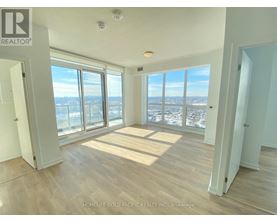 A room with a view of the city through large windows.