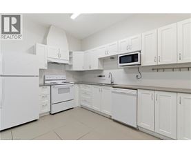 A white kitchen with a refrigerator, microwave, and oven.