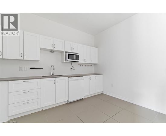 A kitchen with white cabinets and a microwave above the oven.