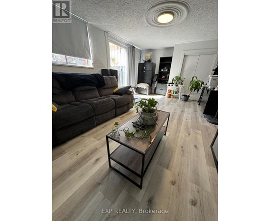 A living room with a grey couch and a glass coffee table.