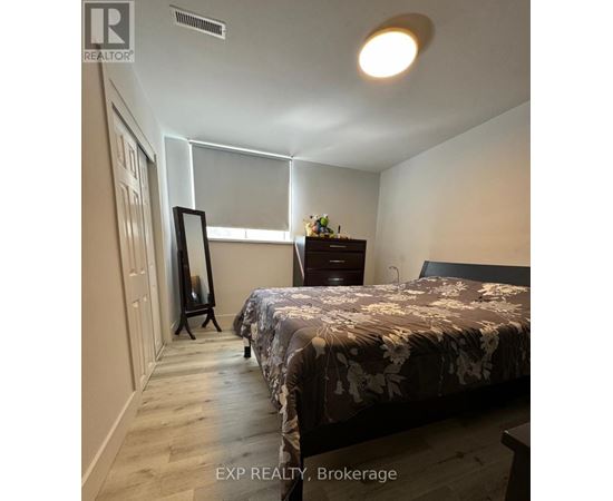 A bedroom with a bed, dresser, and mirror.