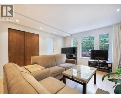 A living room with a couch, chair, and television.