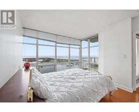 A bedroom with a large bed and a view of the water.