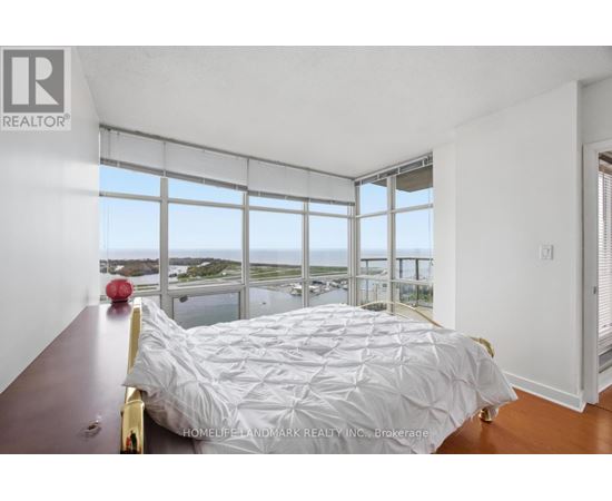A bedroom with a large bed and a view of the water.