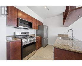 A kitchen with a stove top oven and a refrigerator.