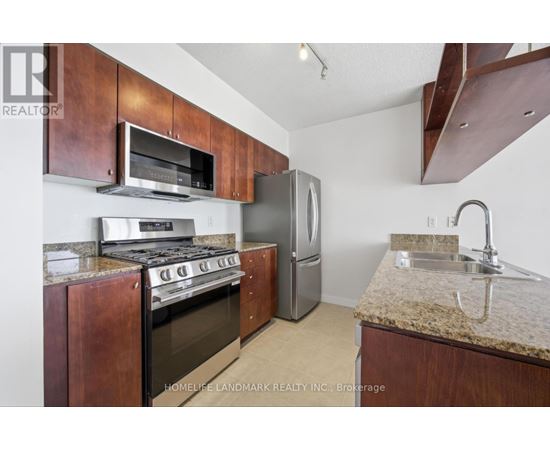 A kitchen with a stove top oven and a refrigerator.