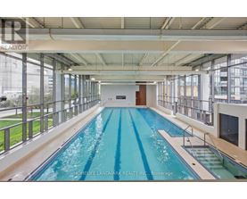 A large indoor swimming pool with a glass wall on one side.
