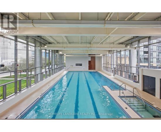 A large indoor swimming pool with a glass wall on one side.