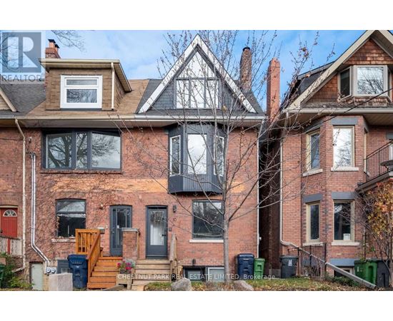 A large brick house with a sign that says "REALTOR" on the roof.
