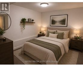 A well-lit bedroom with a large bed and a framed picture on the wall.