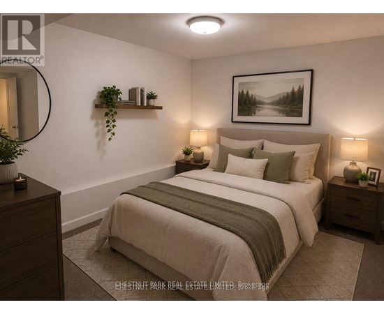 A well-lit bedroom with a large bed and a framed picture on the wall.