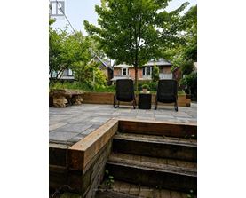 Two black chairs are placed on a wooden deck.