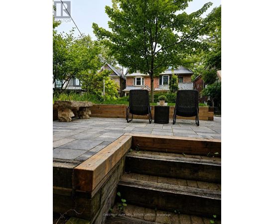 Two black chairs are placed on a wooden deck.