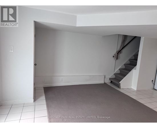 A room with a staircase and a carpeted floor.