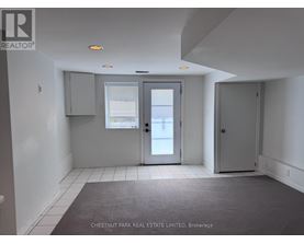 A room with a grey carpet and white walls.