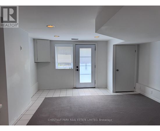A room with a grey carpet and white walls.