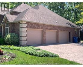 A house with a brown roof and two garages.