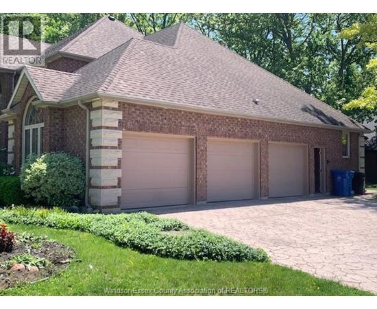 A house with a brown roof and two garages.