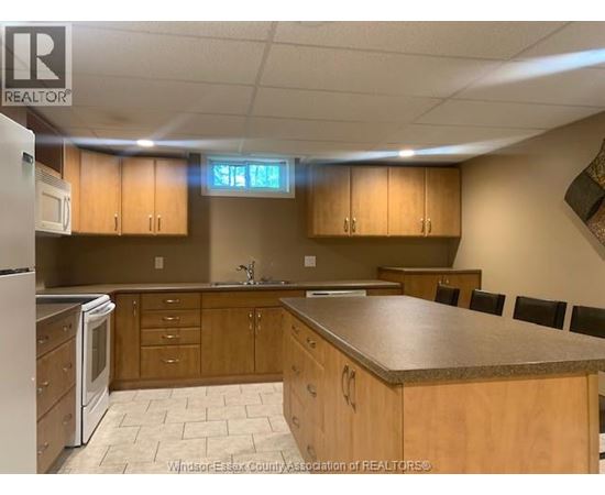 A kitchen with wooden cabinets and a granite countertop.